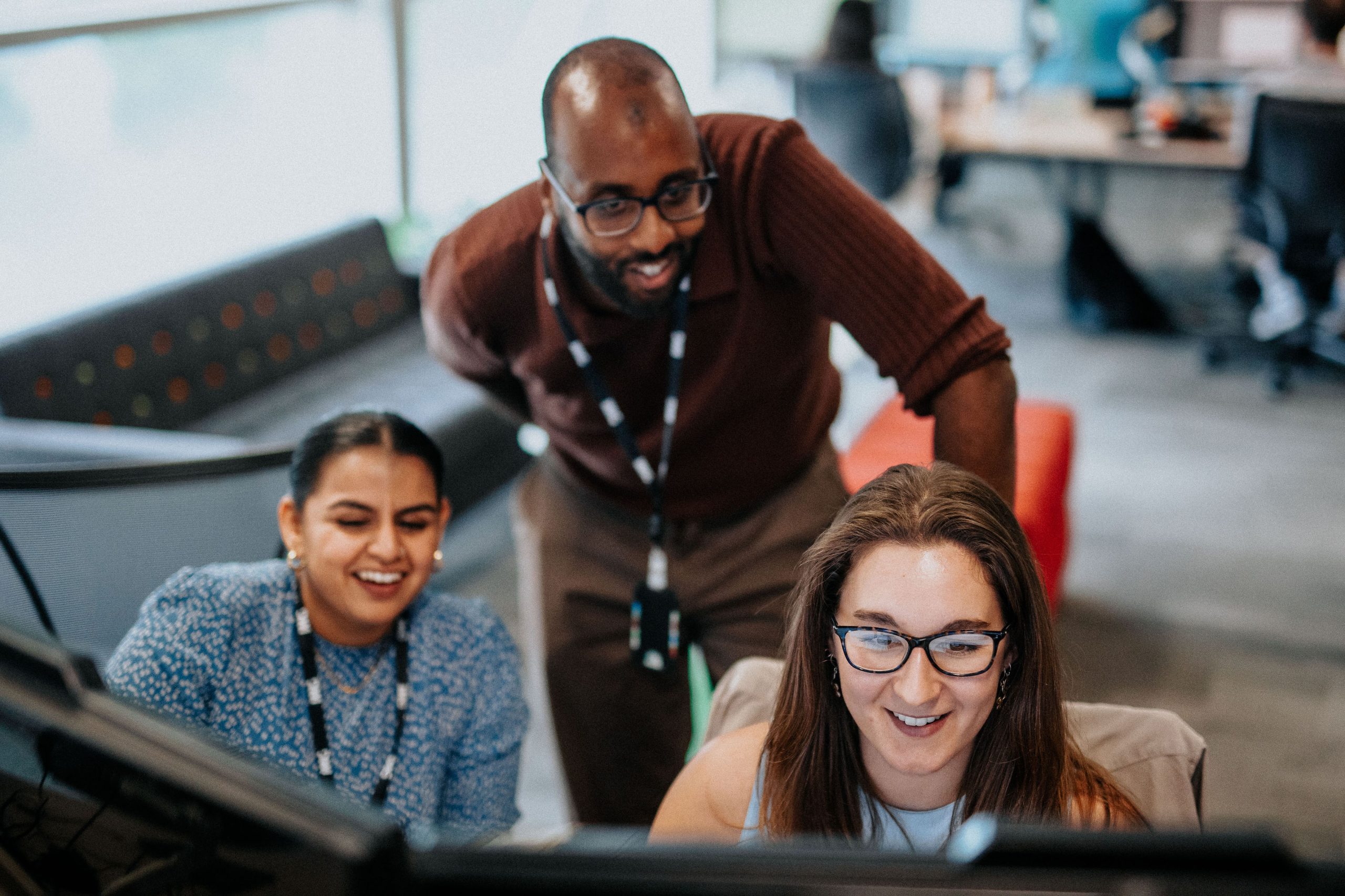 Three people looking at laptop